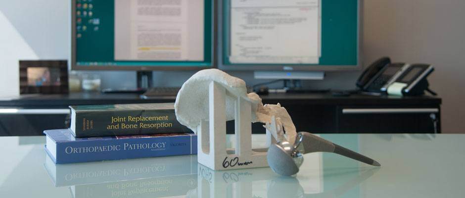 Desk with orthopaedic textbook and metal on metal hip replacement 