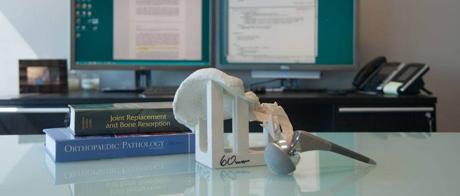 Desk with orthopaedic textbook and metal on metal hip replacement