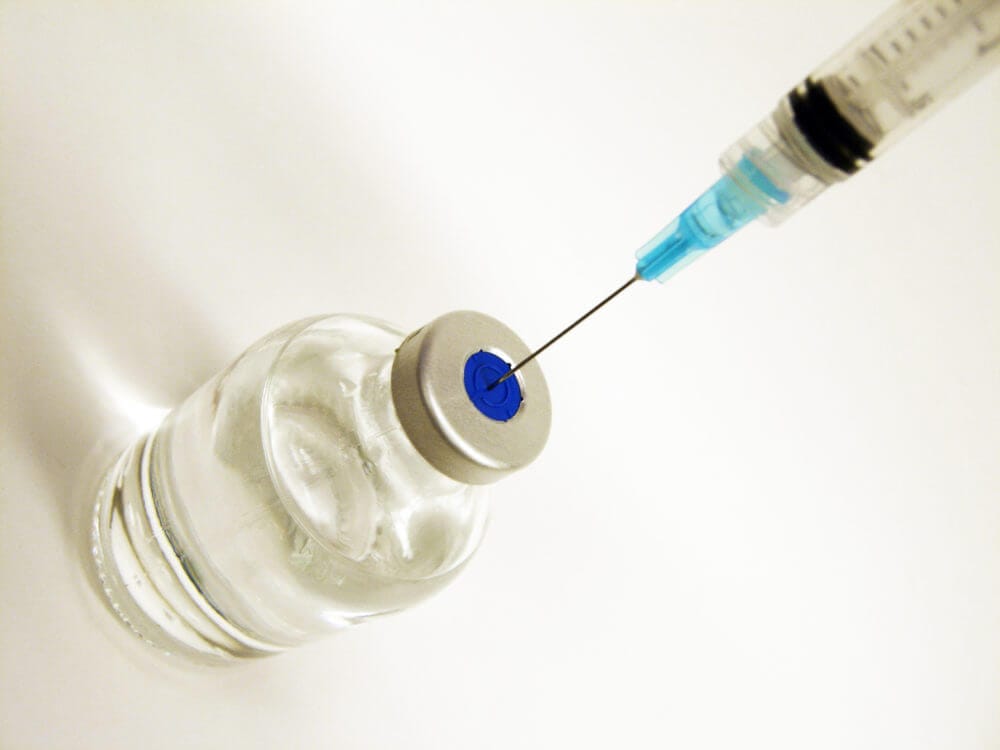 vial of vaccine and syringe going into it